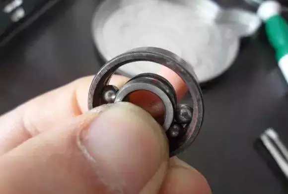 用手將軸承拿起，需要注意要向有滾珠的方向頂住